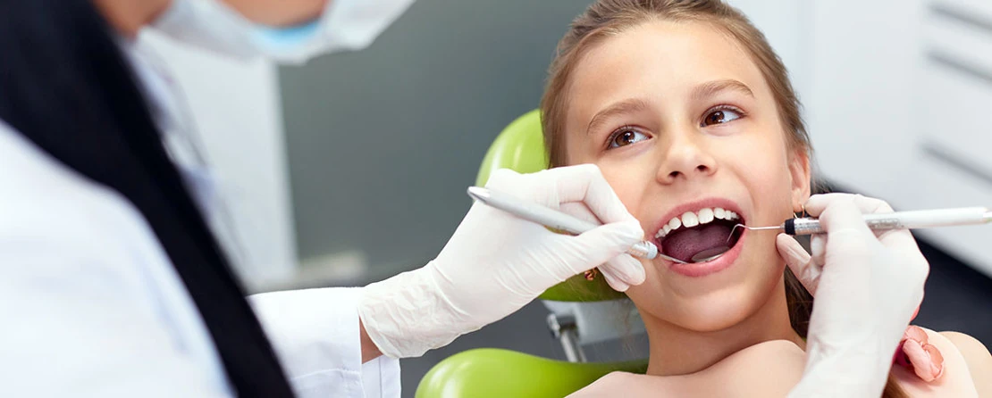на фото девочка лечит зубы в стоматолога ортодонта в клинике Багита