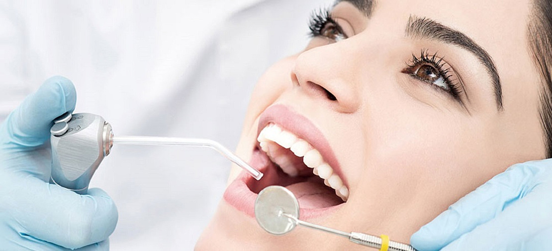 In the photo, a dentist performs professional teeth cleaning in a dental clinic in Cherkassy