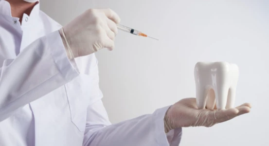 a picture of a dentist with a syringe and a tooth.