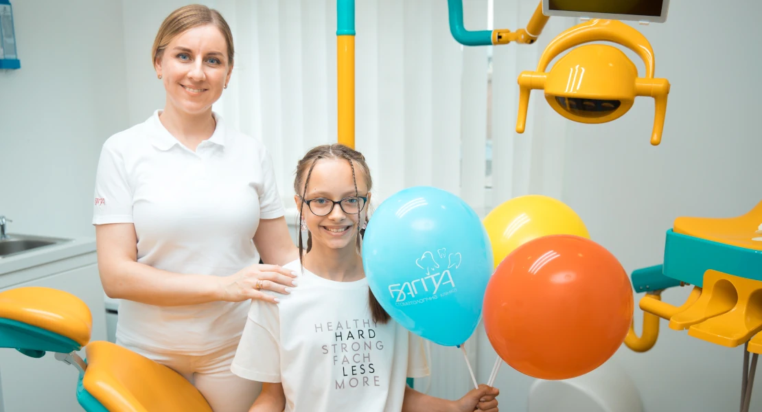 фото дитячого стоматологічного кабінету в клініці Багіта в Черкасах, у ньому лікарка з маленьким радісним пацієнтом, яка тримає в руках фірмову кульку Багіта