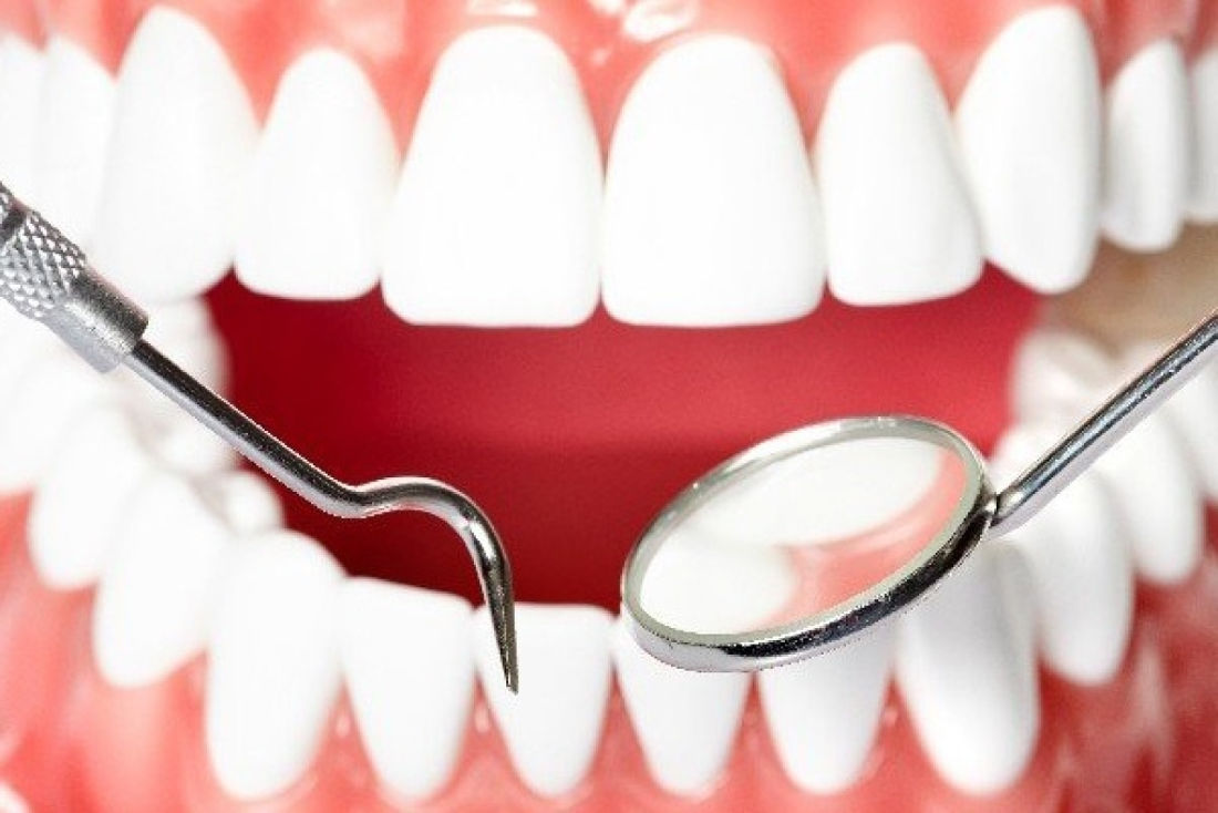 белоснежная улыбка и стоматологический инструмент